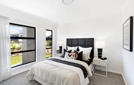 Bed with black upholstered bedhead with double beds and lamps in the Ellerton 223 display home