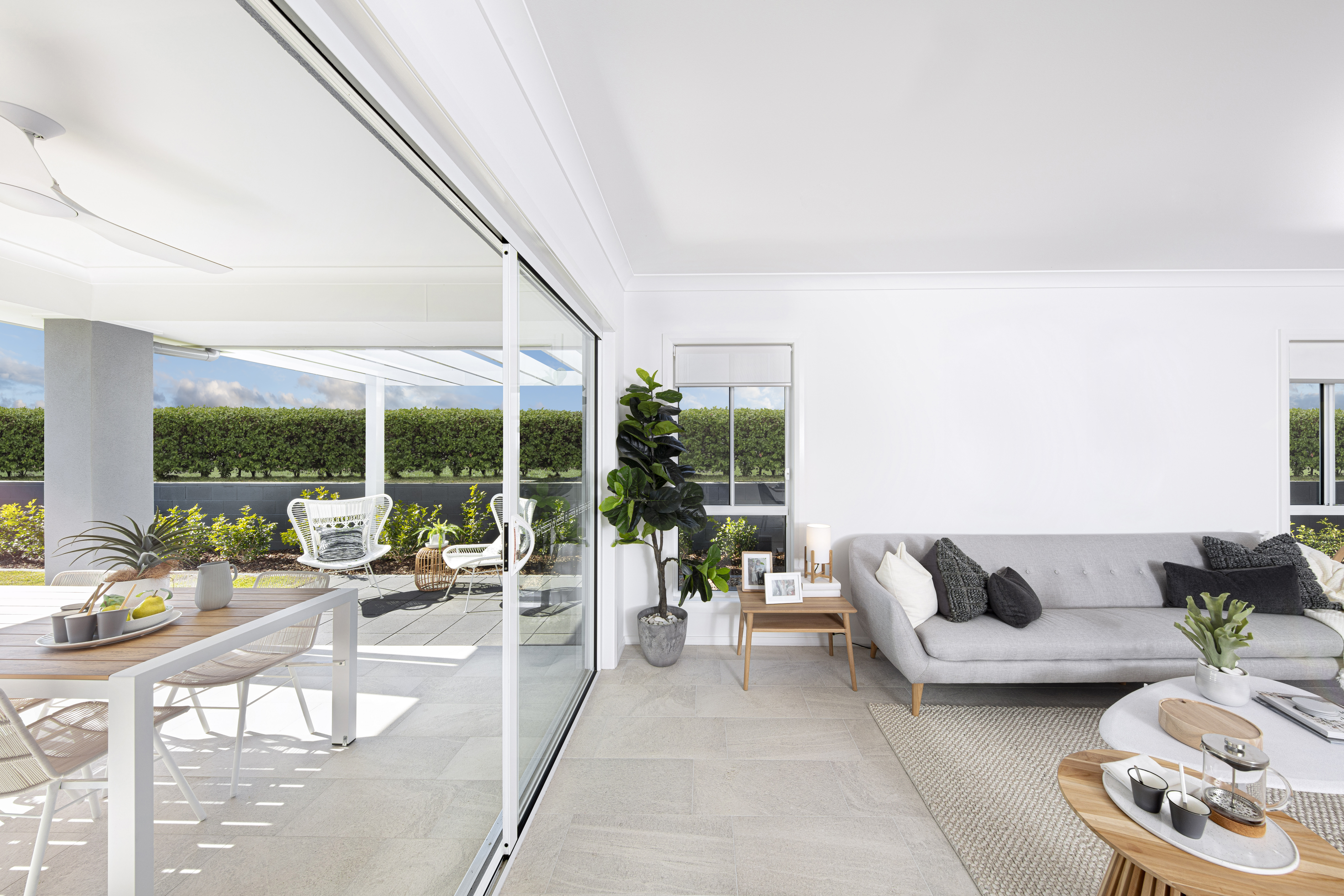 View of the living area in the Lucia One display home parallel to floor to ceiling windows opening up to the outdoor alfresco area