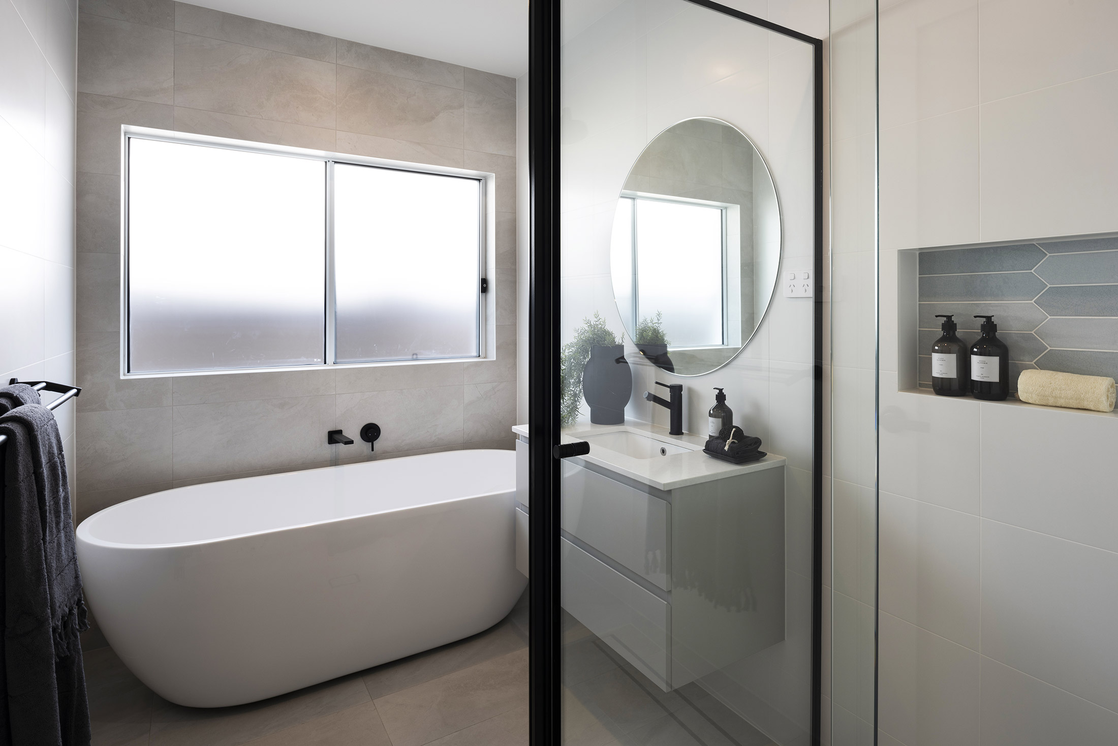 Bathroom in the Avoca display home with shower, single vanity and freestanding bathtub situated below a window