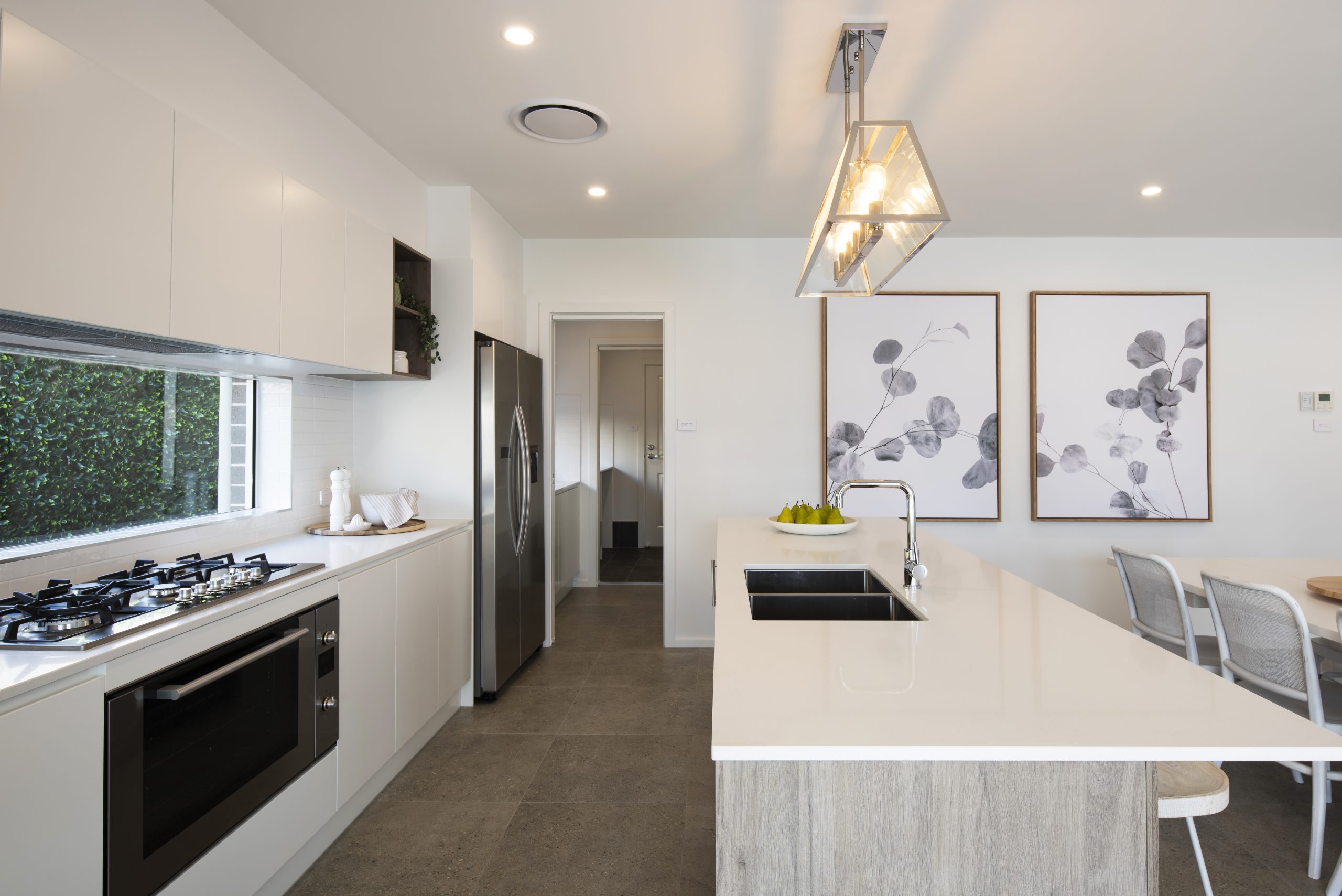 The kitchen in the Avalon 220 display home with a view down to the scullery and laundry