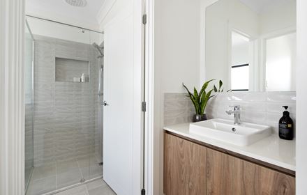 Bathroom in the Ellerton 223 display home with single vanity separated from the shower by a door