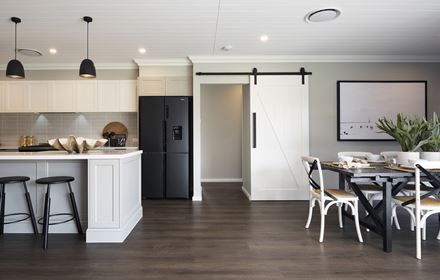 A view of the hallway with white sliding barn door situated between the kitchen and dining area in the Avoca display