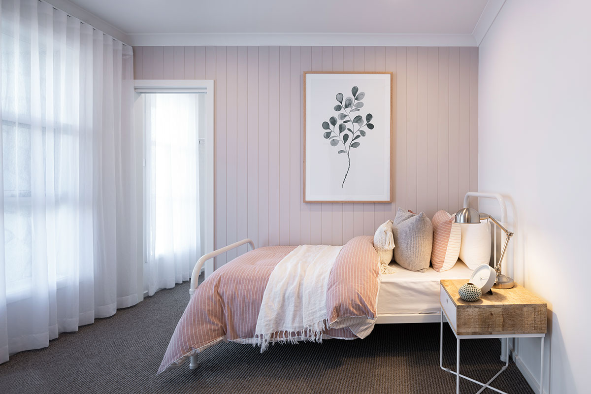 A bedroom styled as a kids room in the Avalon 220 display home with sinle bed against a pink panelled wall