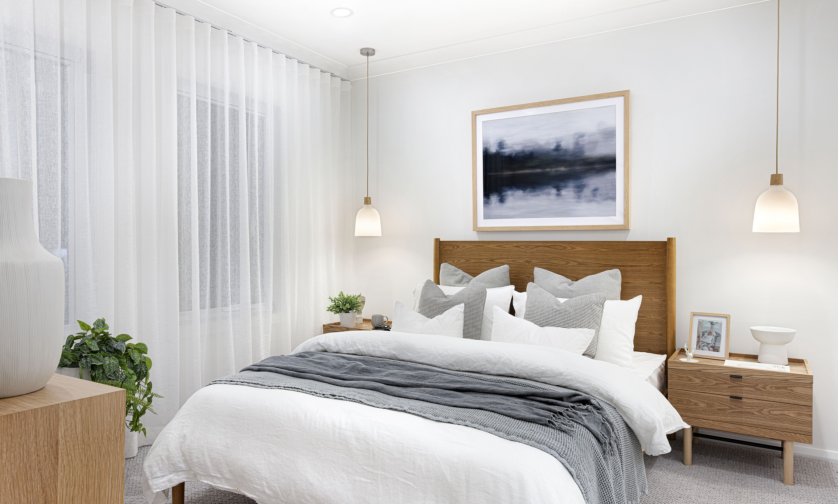 Master bedroom in the Lucia One display home with focus on the bed, double bedsides and pendant lights