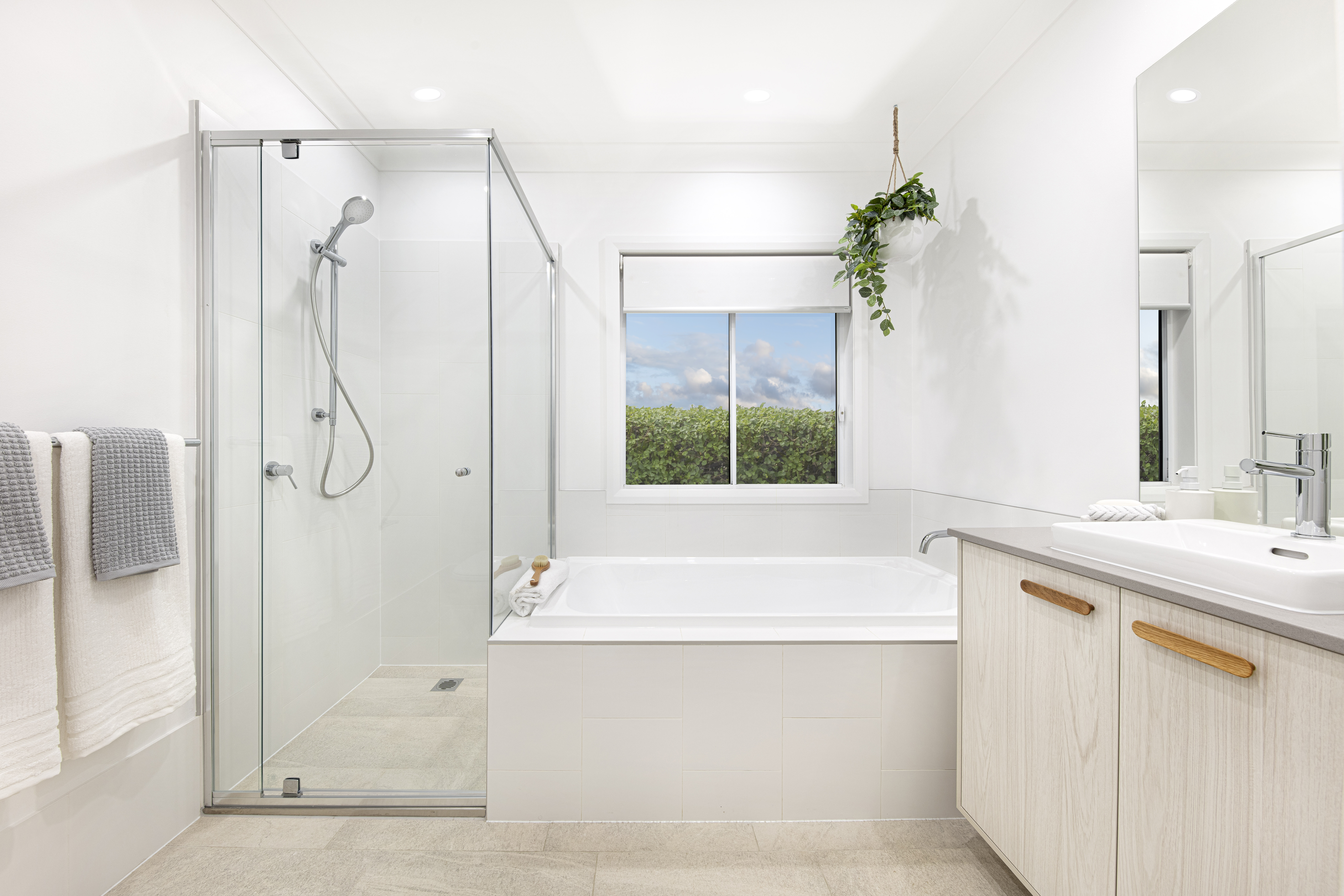Bathroom with single vanity, built in bathtub and shower in the Lucia One display home