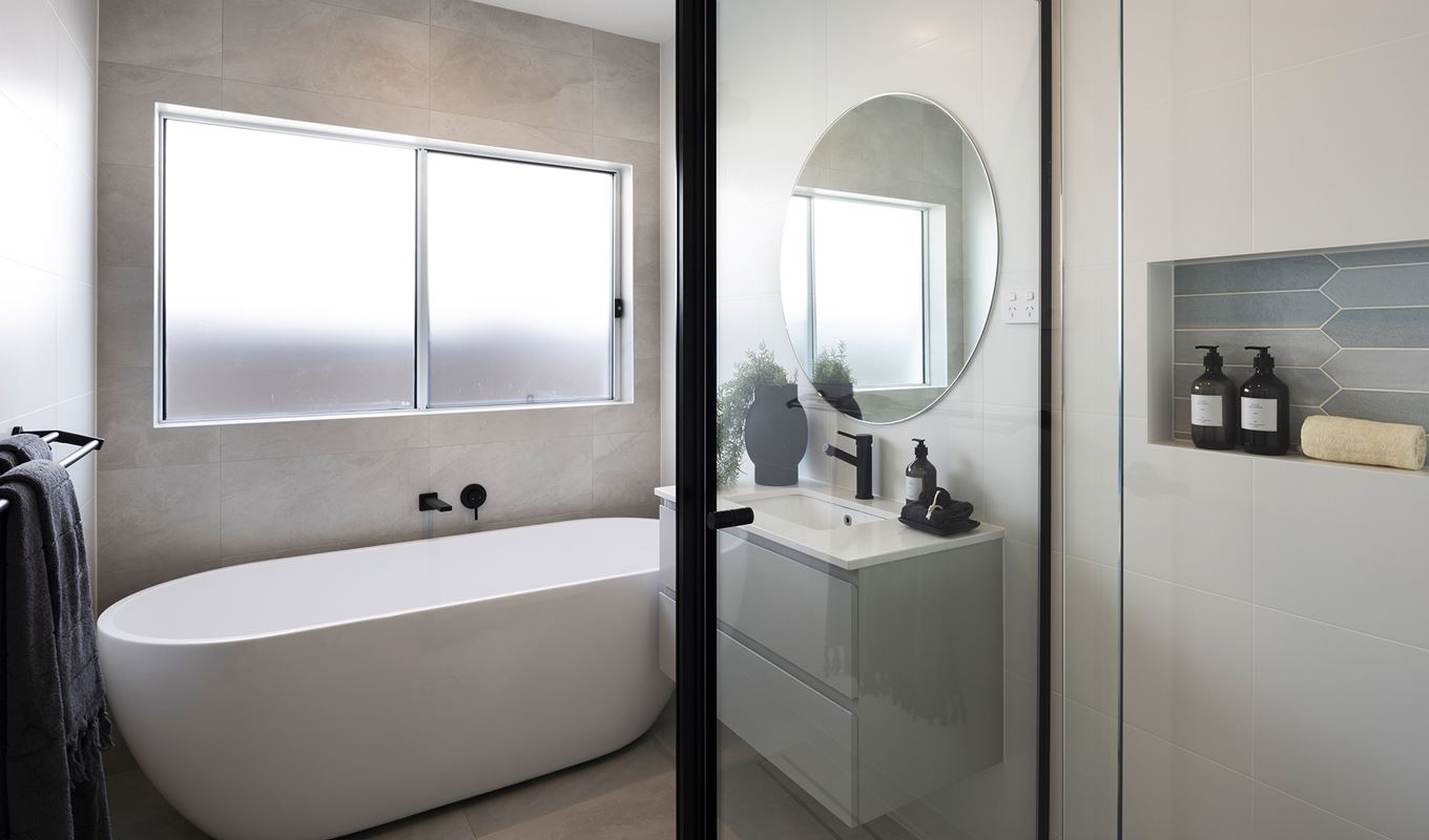 Bathroom in the Avoca display home with shower, single vanity and freestanding bathtub situated below a window